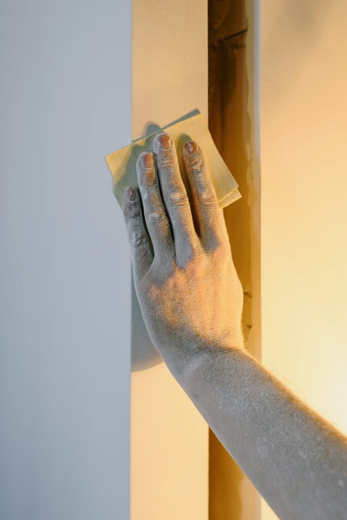 Person using sandpaper on the wall 